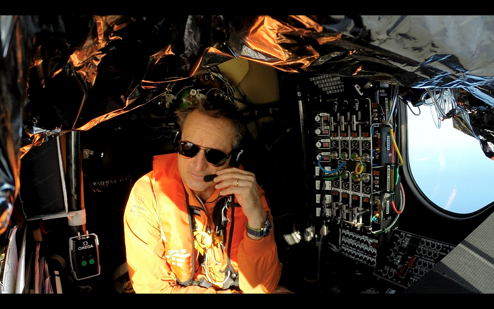Close-up of André Borschberg inside the cockpit of Solar Impulse 2, emphasizing the human element in solar flight